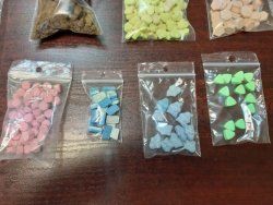 zdjęcie przedstawia kolorowe tabletki ekstazy, znajdują się one w przeźroczystym woreczku z zapięciem strunowym