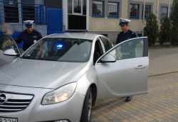 Policjanci Wydziału Ruchu Drogowego na parkingu komendy wsiadają do radiowozu nieoznakowanego Opel Insignia